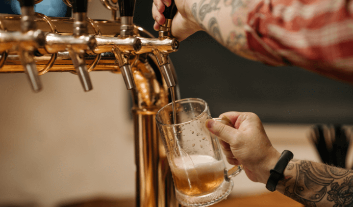 Persona sirviendo una cerveza en un pub